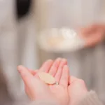 Kommunikant tar emot Kristi kropp i mässan